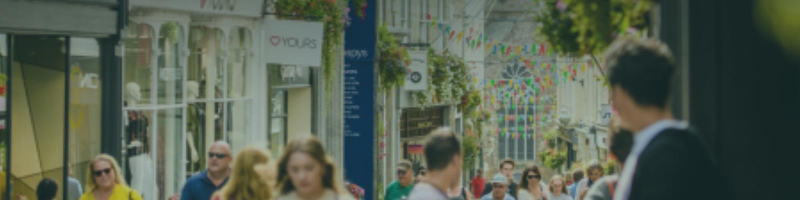 bustling image of people walking in front of shops