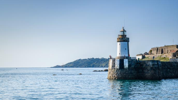 a lighthouse on the coast in the sunshine